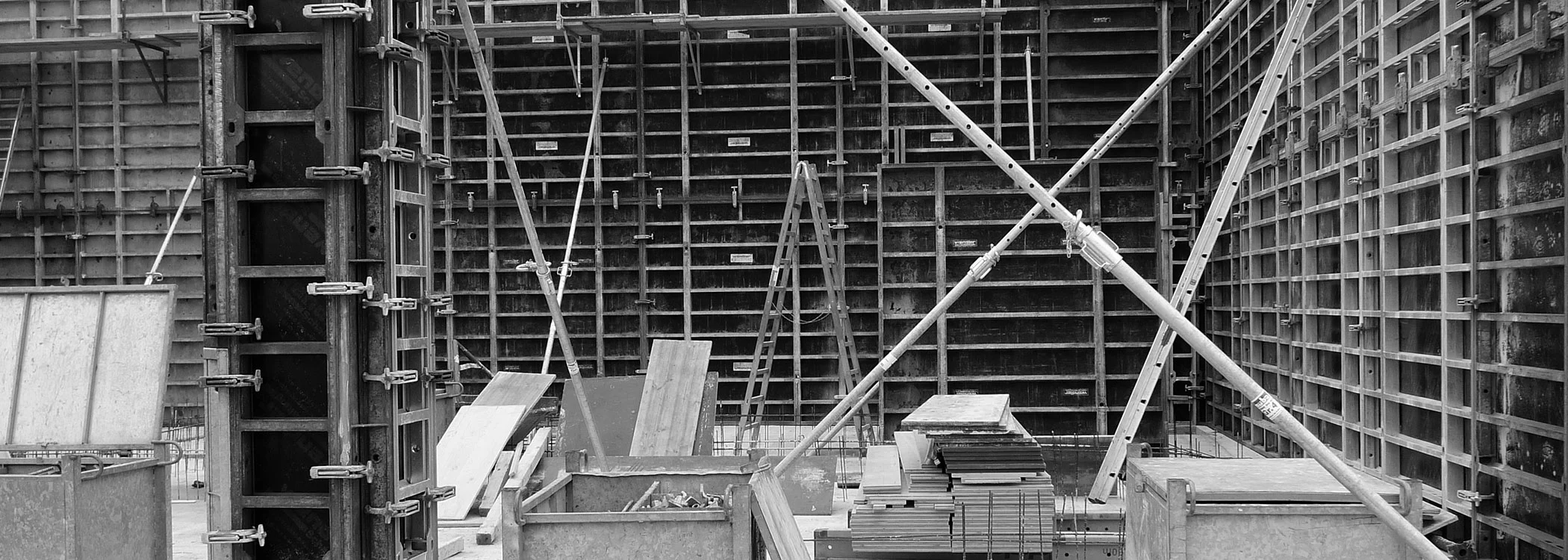 Baustelle mit Wandschalungen, Stützen und Gerüsten in Schwarzweiß